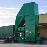 Dock-fed extended height dumper in a CP125FW loading a walking floor trailer.